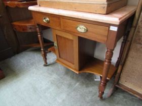 An Edwardian walnut washstand having a pink marble top with two drawers and pot cupboard below