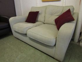A modern beige button back two seater settee