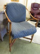 A bamboo and wicker chair with blue upholstered cushions