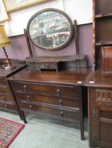 An early 20th century dark stained dressing chest with bevelled glass mirror