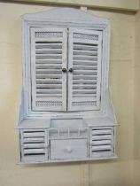 A reproduction pale blue painted distressed wall mounted mirror with shutters and drawer