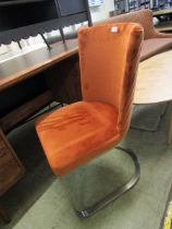 A modern mid-20th century style office chair with orange upholstered seat on chrome base