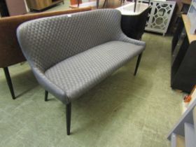 A modern grey faux leather upholstered bench on cylindrical legs