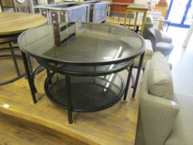 A modern black metal circular smoked glass topped occasional table with a matching table to under