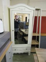 A modern cream painted mirrored door wardrobe with drawer to base