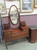 An early 20th century mahogany and inlaid dressing chest, the oval mirror with bevelled glass
