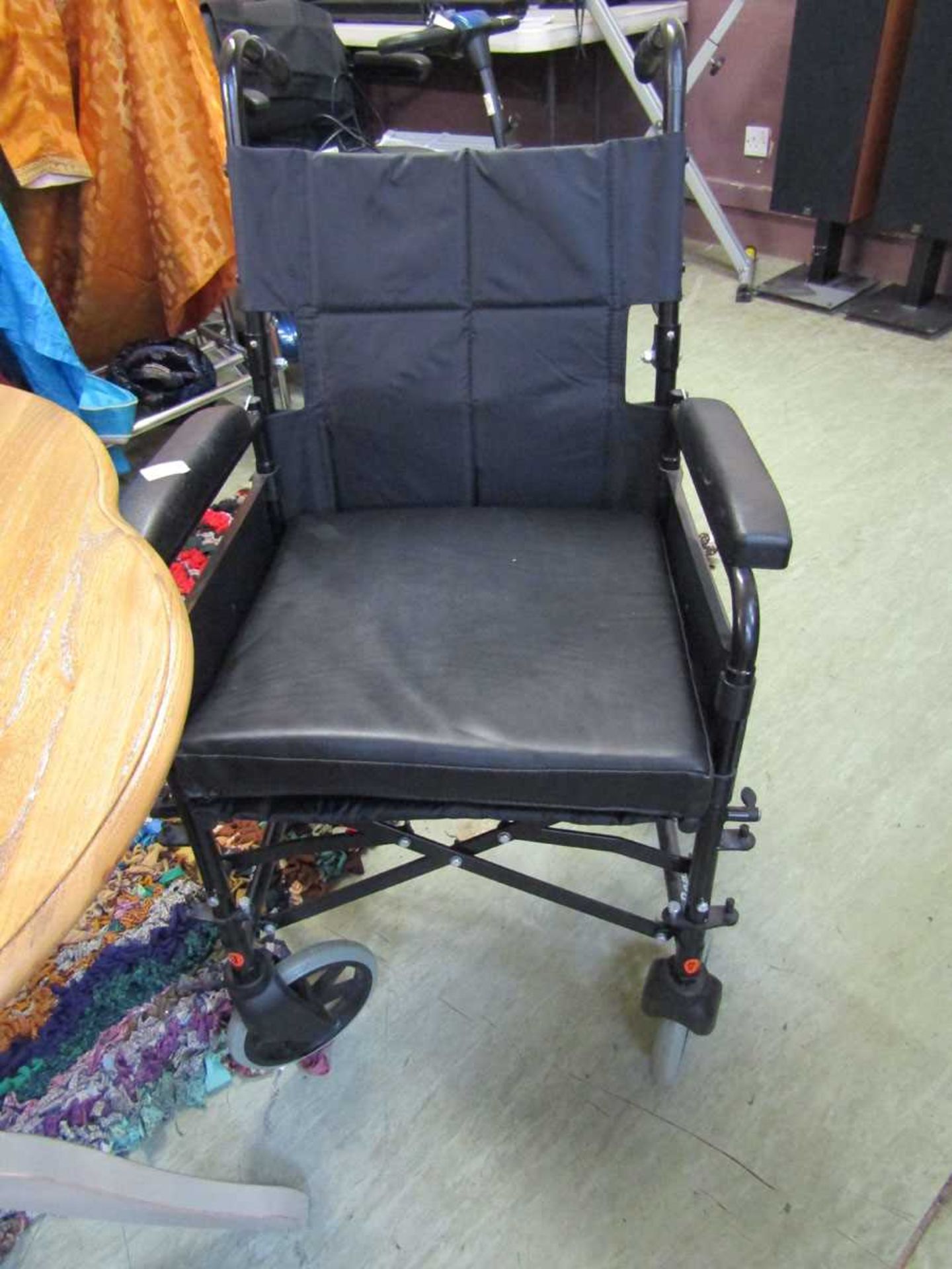 A black metal tubular folding wheelchair