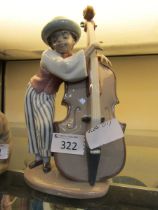 A Lladro ceramic figurine of young boy playing double bass