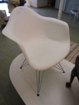 A white Perspex chair on chrome supports