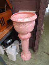 A pink ceramic jardiniere on matching stand