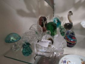 An assortment of mid-20th century style glass paperweights to include Waterford Crystal, Stuart