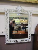 A white painted metal framed ornate wall mirror