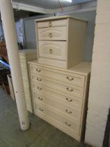 A modern laminated chest of five drawers together with a pair of matching bedside chests and one