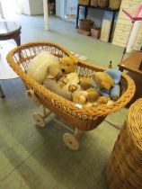 A wicker crib on white painted wheels together with a selection of soft toys