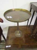 An engraved and embossed brass pedestal table