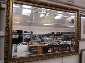 A large ornate gilt framed reproduction bevel glass wall mirror