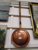 A brass and copper bed warming pan