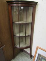 An early 20th century Sheraton revival mahogany inlaid bow front glazed display cabinet on splayed