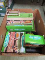 A box containing a selection of Subbuteo accessories to include plastic fence, goal, stands, etc