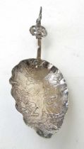 A Dutch white metal spoon with embossed scenes of dancing. Approx. weight 29g, l. 14 cm.