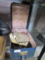A vanity case containing a selection of purses, a harmonica, etc