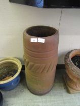 A terracotta garden chimney pot planter