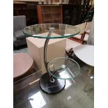 A modern plate glass two tier occasional table on chrome support with black marble style base