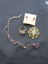 A 9ct gold ring with purple stones together with a pair of 9ct gold earrings with purple stones, a