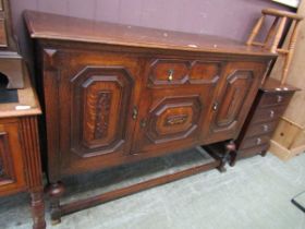 A mid-20th century oak sideboard having a centre drawer above cupboard door flanked by two panel