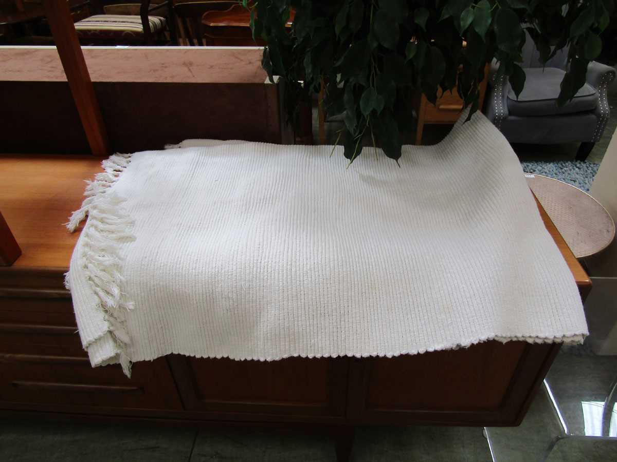 A cream wool rug Dimensions: L, 200cm , W, 120cm. No apparent stains or damage, may need cleaning.