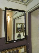 A modern wood and brass cornered bevel glass wall mirror