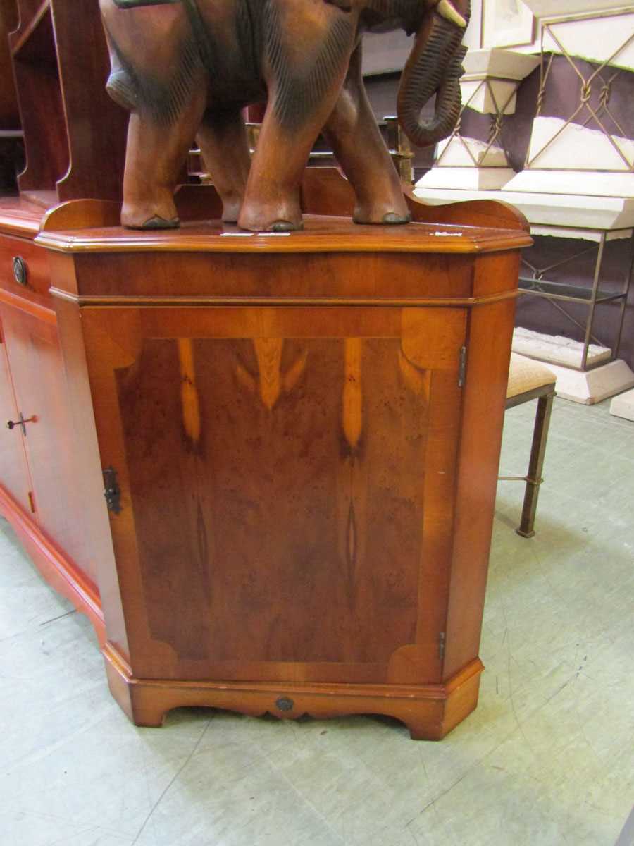 A reproduction yew corner cupboard with raised back