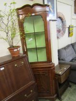 A reproduction full height corner cabinet having a glazed top section