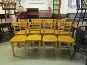 A set of eight reproduction beech effect dining chairs