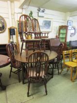 An oak gate leg table together with three standard and two carver wheel back chairs