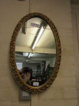 A mid-20th century ornate gilt framed bevel glass wall mirror