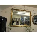 A large ornate gilt framed rectangular bevel glass wall mirror