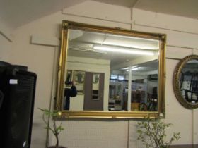 A large ornate gilt framed rectangular bevel glass wall mirror