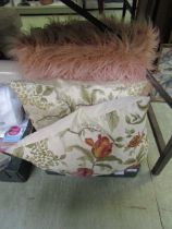 A tray containing four cushions, to include pink fluffy cushions
