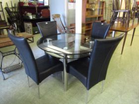 A high quality modern chrome and smoked glass circular dining table with a set of four matching