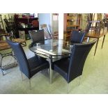 A high quality modern chrome and smoked glass circular dining table with a set of four matching