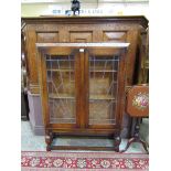 A mid-20th century carved oak leaded glazed two door bookcase