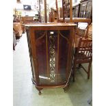 A walnut veneered bow fronted glazed display cabinet
