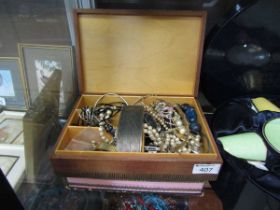 A jewellery box containing an assortment of costume jewellery to include watches, beads, etc