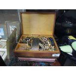 A jewellery box containing an assortment of costume jewellery to include watches, beads, etc