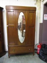 An Edwardian mahogany inlaid wardrobe having a mirrored centre door with drawer to base