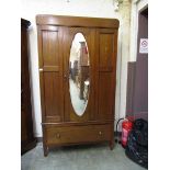 An Edwardian mahogany inlaid wardrobe having a mirrored centre door with drawer to base