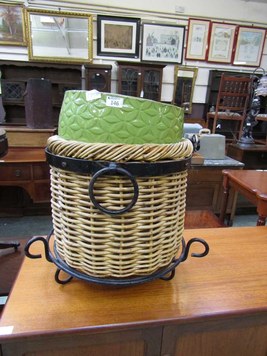 A green glazed ceramic planter together with a wicker basket with metal banding