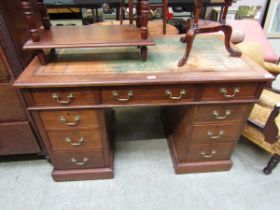 An early 20th century walnut twin pedestal desk with distressed tooled green leather inset to top by