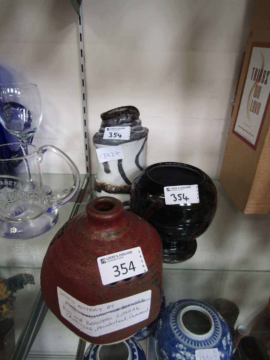 Three pieces of mid-20th century style studio pottery consisting of hexagonal brick red bud vase,